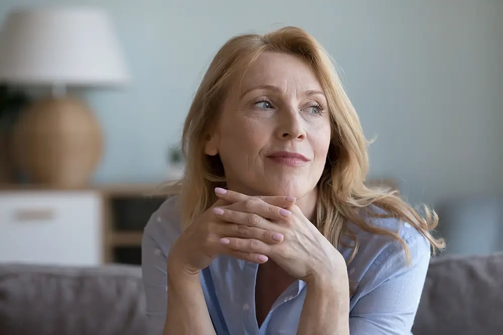 senior mature blonde woman leaning chin on hands